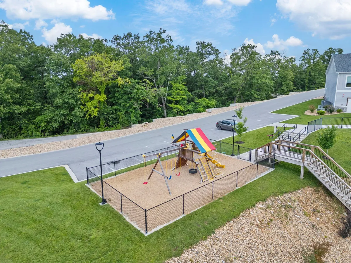 A joyful exterior shot of a colorful playground with swings and a canopy. Children are engaged in play, creating a vibrant, family-friendly vibe that speaks to the property's appeal for guests with young children.