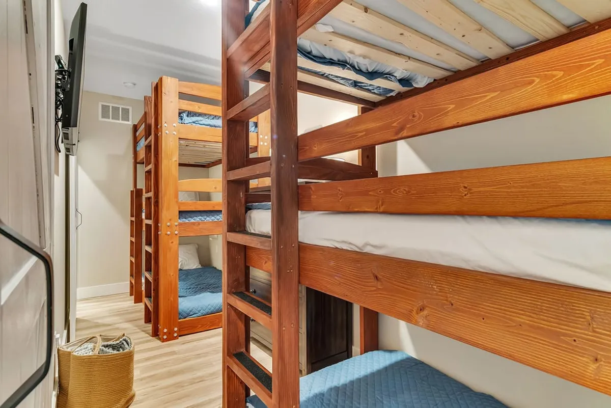 A playful and inviting bunk room with sturdy bunk beds, woven basket for toys or storage, and cheerful blue bedding. The space is designed to encourage sleepovers, late-night chats, and fun bonding moments among children or teens.